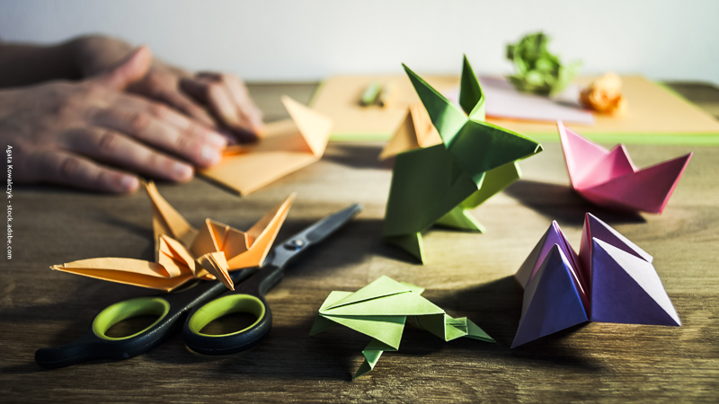 Atelier d’origami pour enfants : pliages colorés en papier en forme d’animaux et de bateaux, une activité créative et relaxante pendant les vacances.