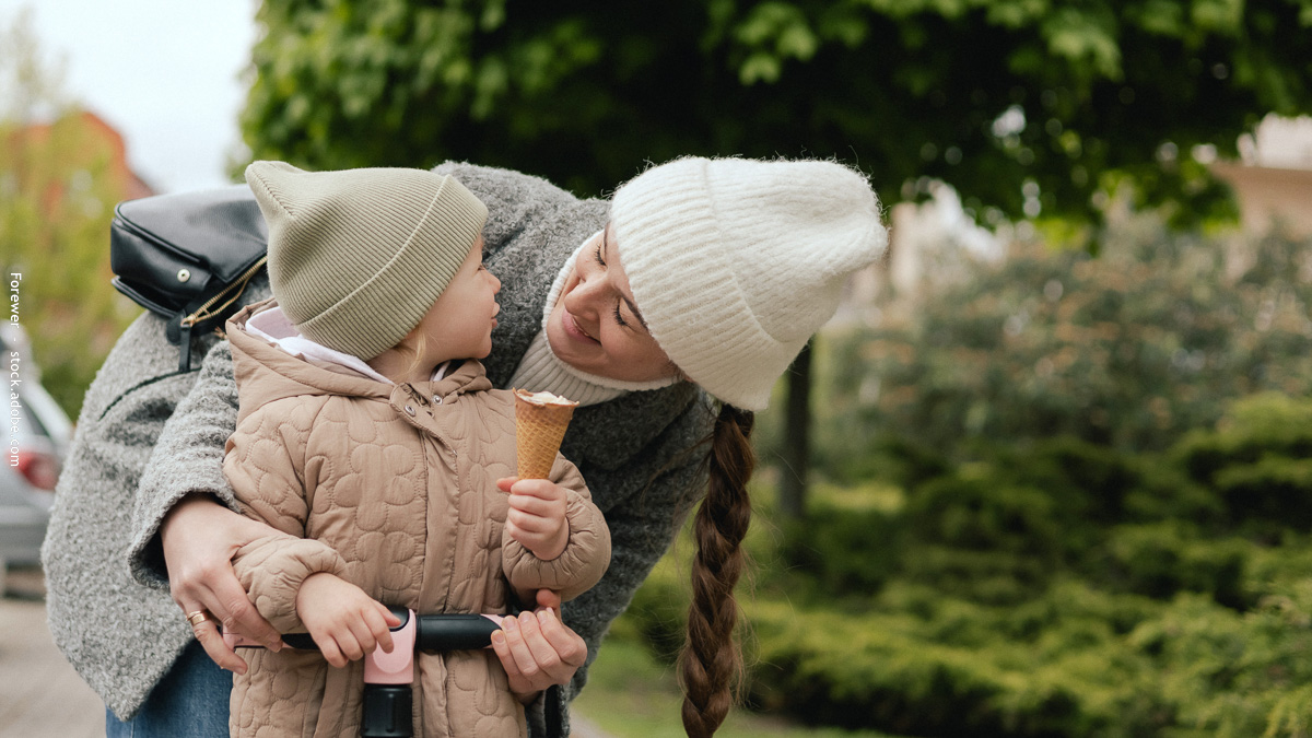 Maman avec ça fille sur une trotinnette qui mange une glace