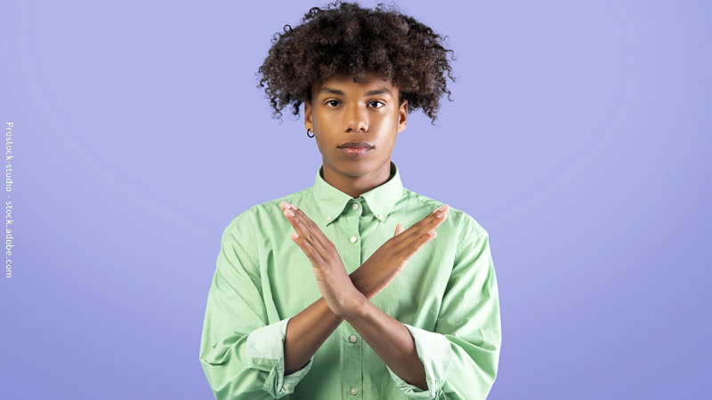 Adolescent croisant les bras en signe de refus, illustrant le choix d’arrêter une activité extrascolaire.