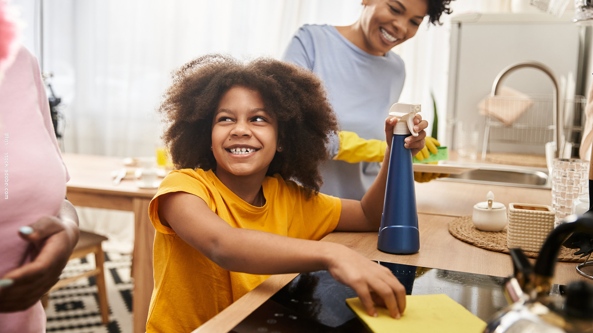 Enfant qui participe aux tâches ménagères aux côtés de ses parents, symbole d’un partage équitable et d’une organisation familiale sereine.