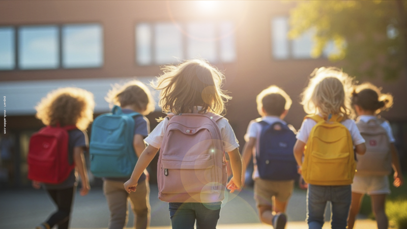 Enfants avec cartables marchant vers l’école, illustrant la rentrée au CP, l’entrée en élémentaire et l’anxiété liée au changement.