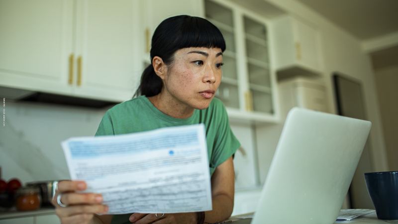 Une mère célibataire concentrée sur ses démarches administratives en ligne, symbolisant la complexité des aides sociales pour les familles monoparentales.