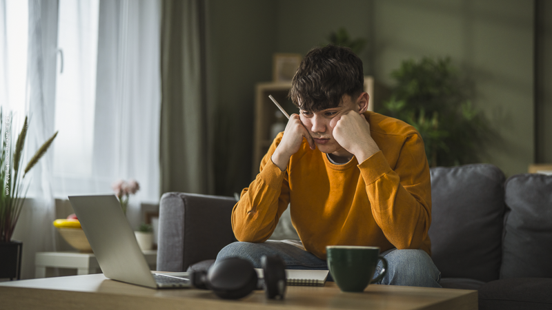 Jeune garçon pensif devant ses devoirs, symbolisant le découragement et la peur de l’échec face à une difficulté.