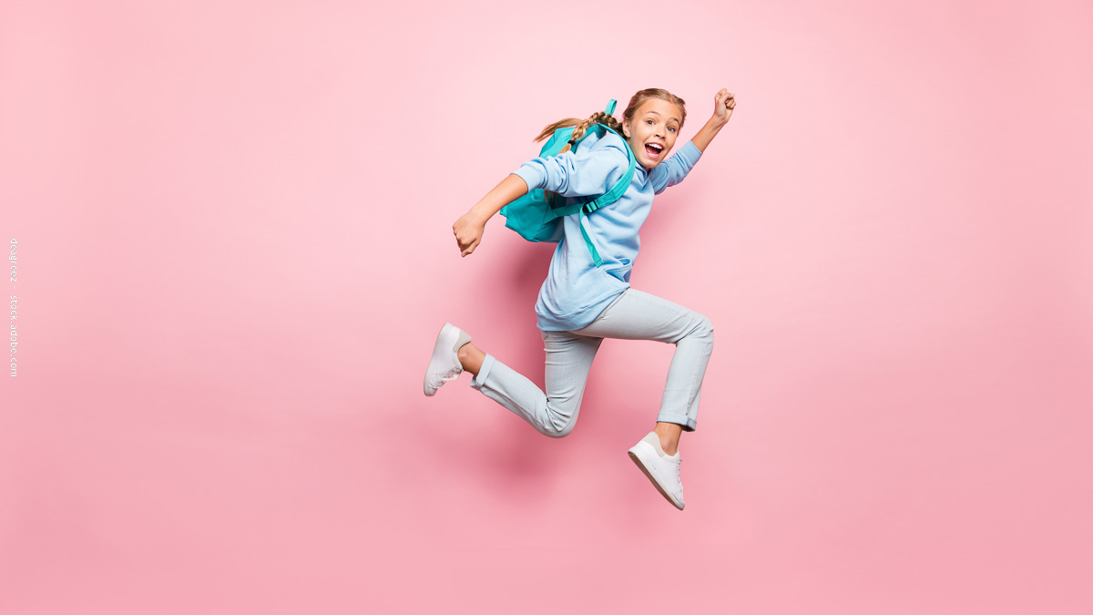 Enfant joyeux sautant avec un cartable léger sur le dos, symbole d’une rentrée au CP sans douleur ni fatigue grâce à un sac bien choisi.