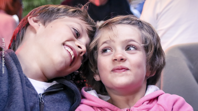 Frère et sœur proches et souriants, symbolisant le lien affectif et la complicité au sein de la fratrie.