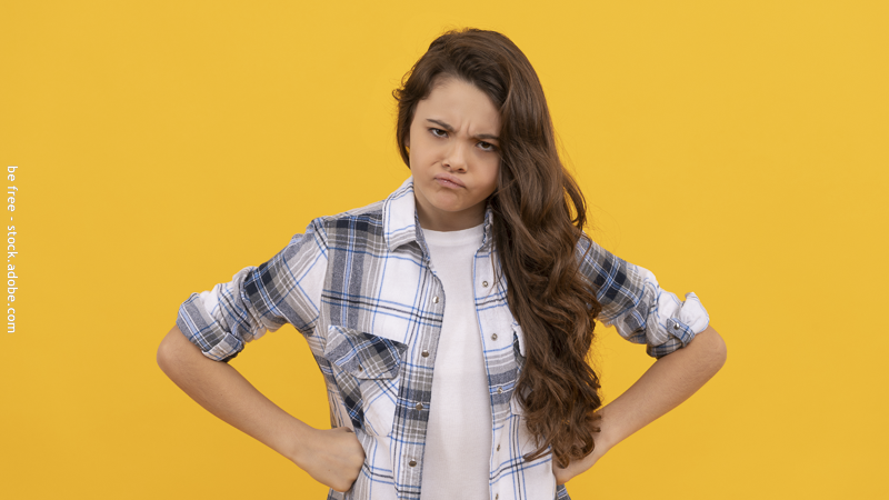 Enfant faisant un geste de refus avec les bras croisés, illustrant une attitude de contradiction ou d’opposition.