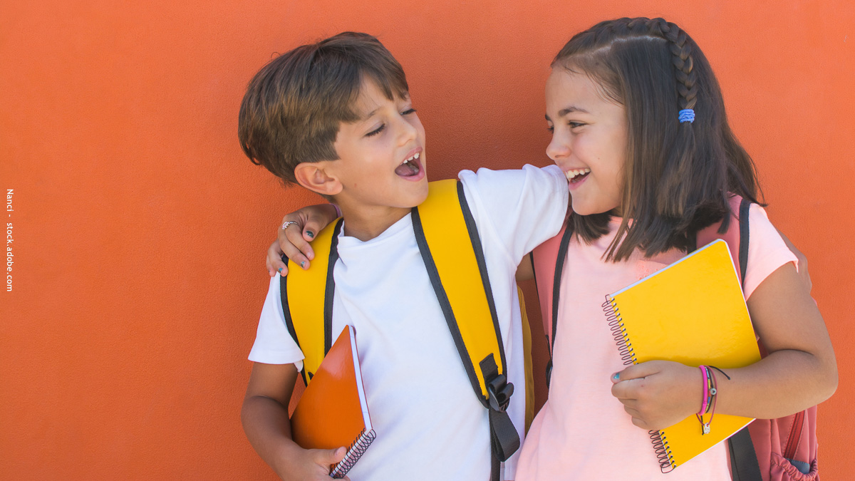 Deux enfants souriants avec leurs cartables et cahiers, symbole d’une rentrée scolaire sereine et réussie au CP ou en 6e.