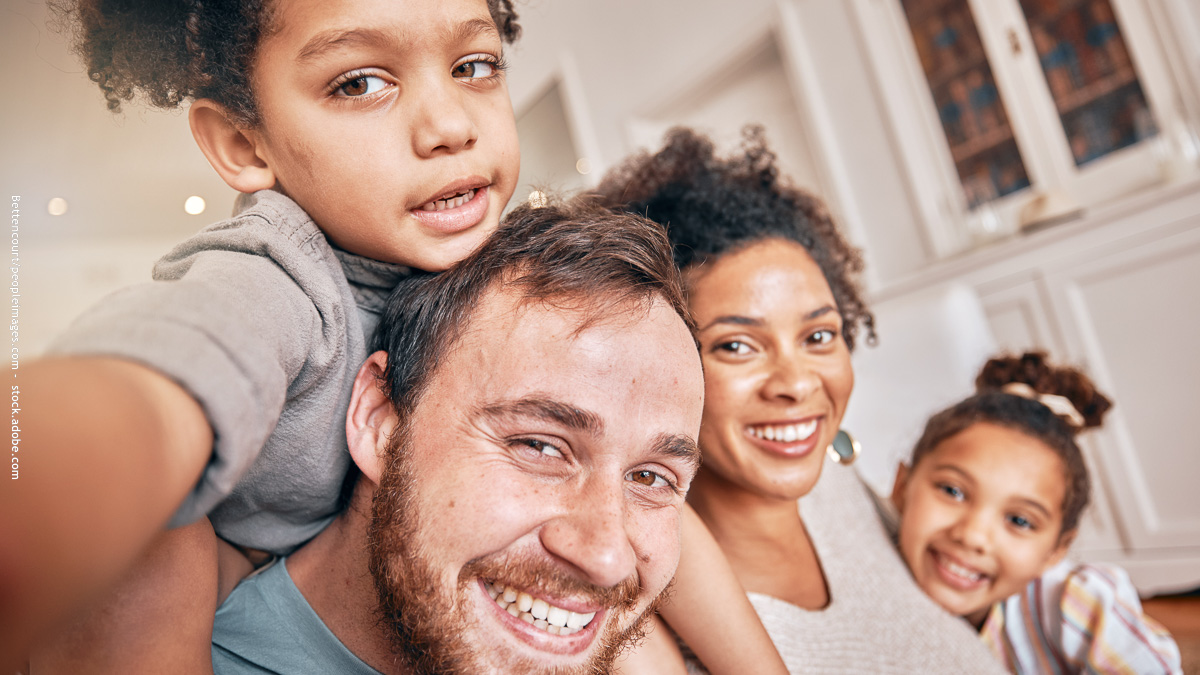 Famille recomposée souriante et complice, symbole de solidarité et de bonne entente pour aborder la rentrée scolaire sereinement.