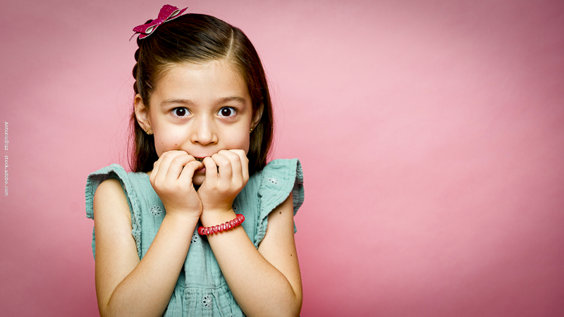 Enfant anxieux sur fond rose, exprimant la peur et l’inquiétude, symbolisant les émotions intenses à gérer chez les enfants.