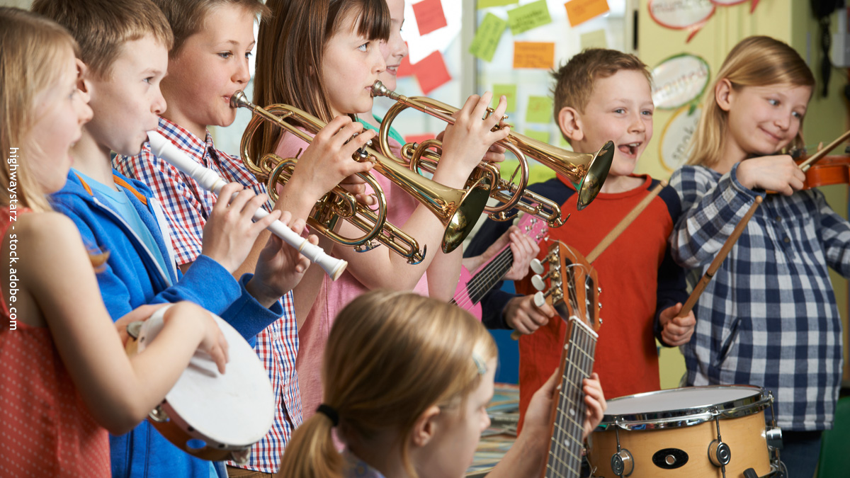 Groupe d’enfants jouant de la musique avec divers instruments lors d’une activité extrascolaire, favorisant créativité, socialisation et épanouissement.