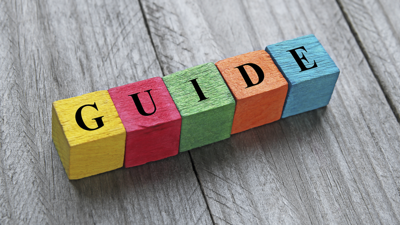 Le mot “GUIDE” formé par des cubes colorés en bois, symbolisant un guide pratique pour les parents isolés.