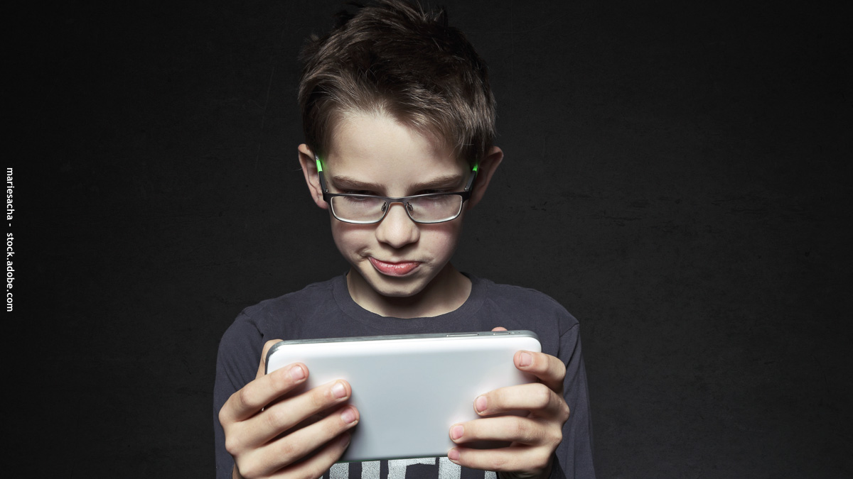 Enfant avec des lunettes qui regarde un téléphone