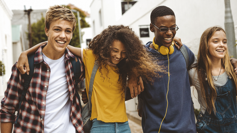 Groupe d’adolescents souriants et solidaires, illustrant la diversité, l’amitié et l’importance du respect des différences.